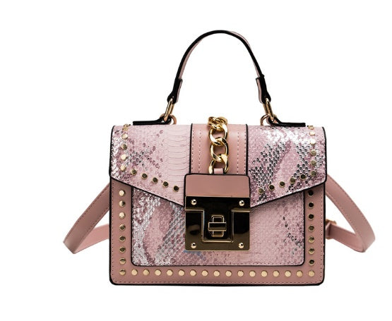 Pink women's crossbody alligator bag with gold accents