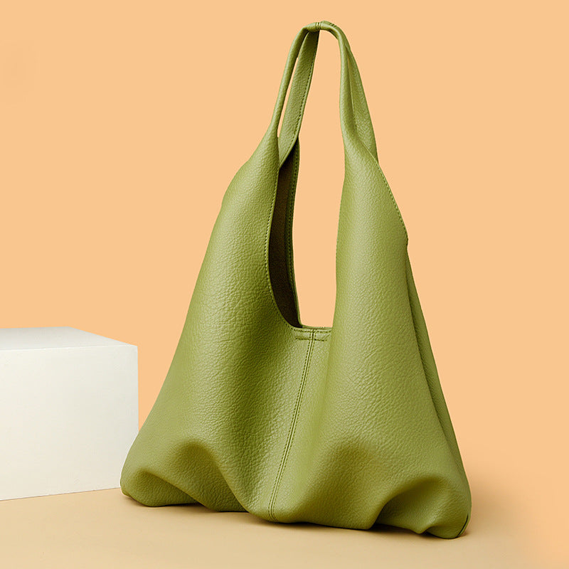 Green leather underarm shoulder bag on a beige background