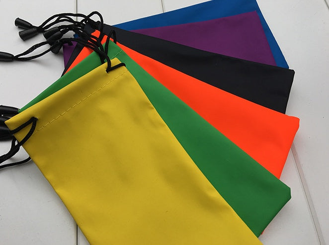 Colorful drawstring bags in various colors on a white surface