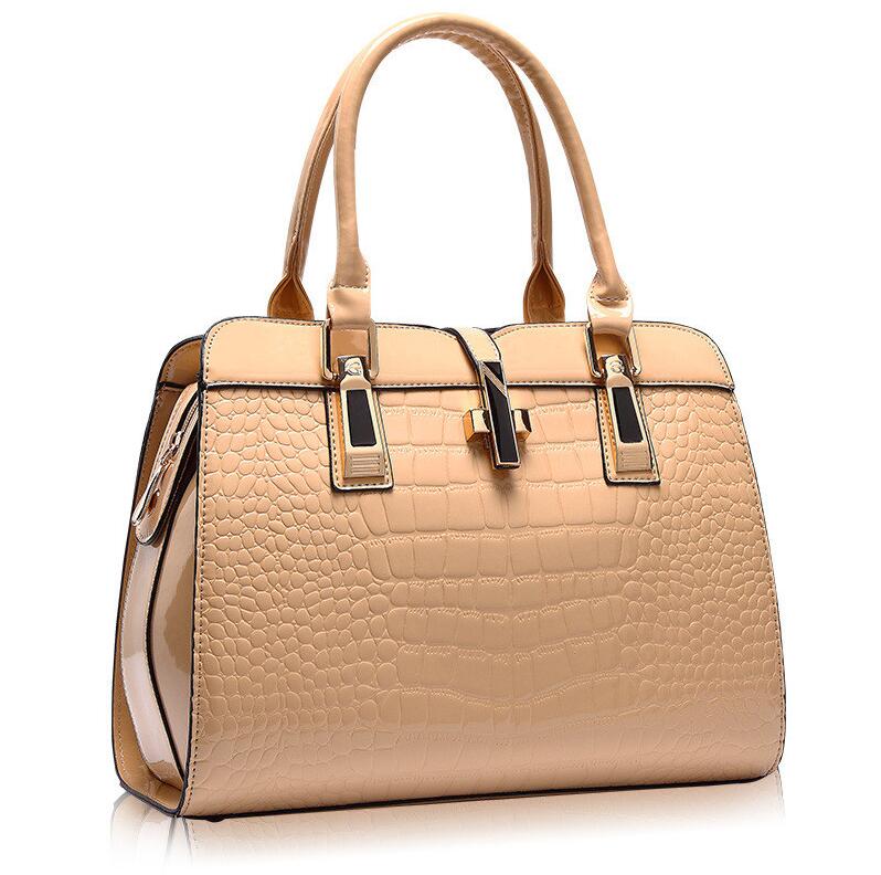 Beige crocodile pattern handbag with clear side panels on a white background