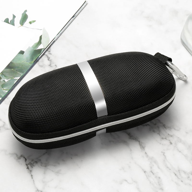 Black and silver zippered case on a marble surface with green leaves in the corner