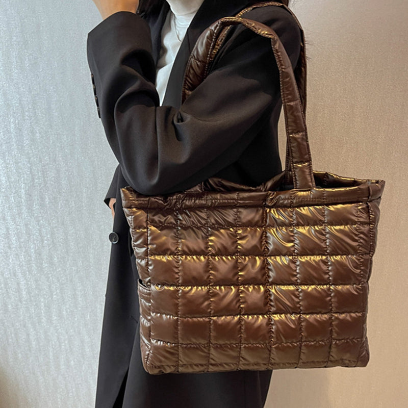 Brown quilted women's plaid shoulder bag held by a person