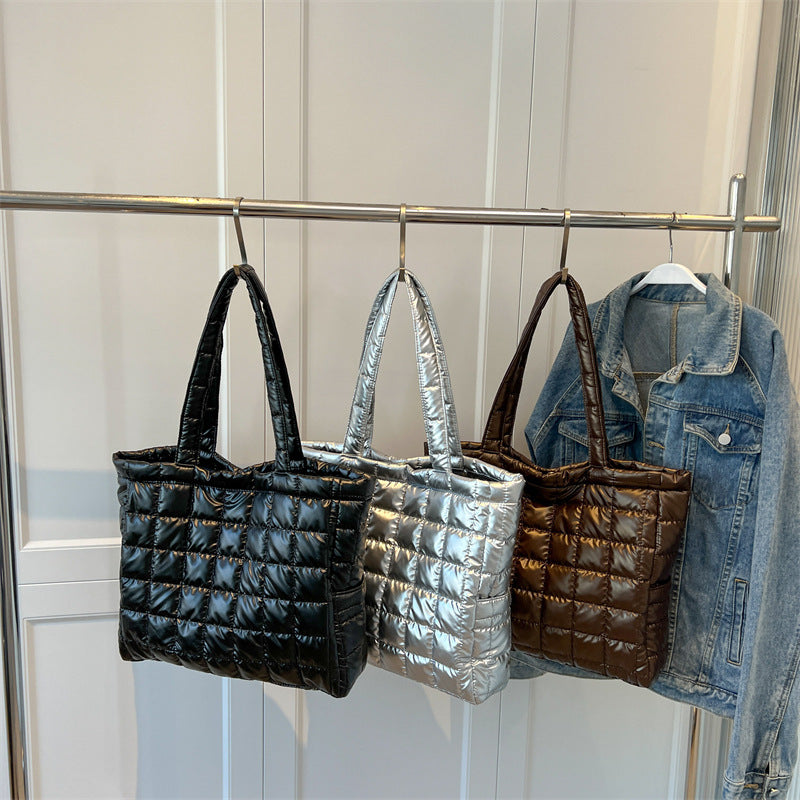 Three puffer women's plaid shoulder bags and a denim jacket hanging on a rack