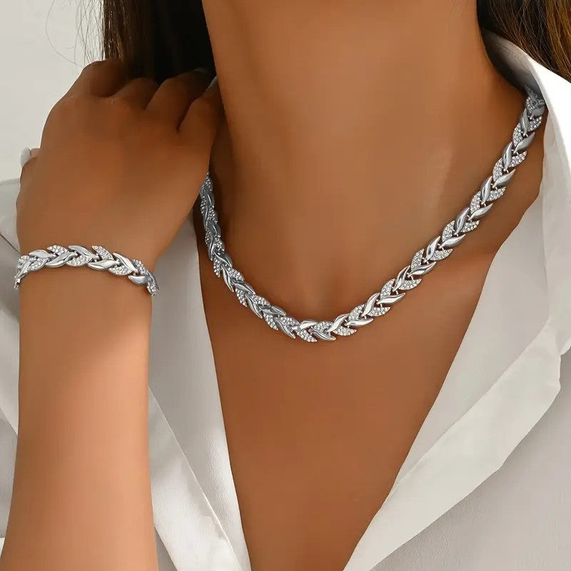 Silver braided necklace and bracelet on a person wearing a white shirt.