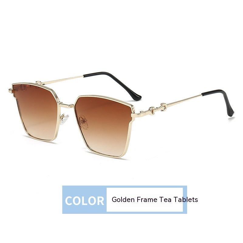 Sunglasses with a gold frame and brown gradient lenses on a white background.