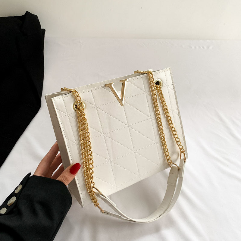 White women's leather crossbody bag with gold chain strap
