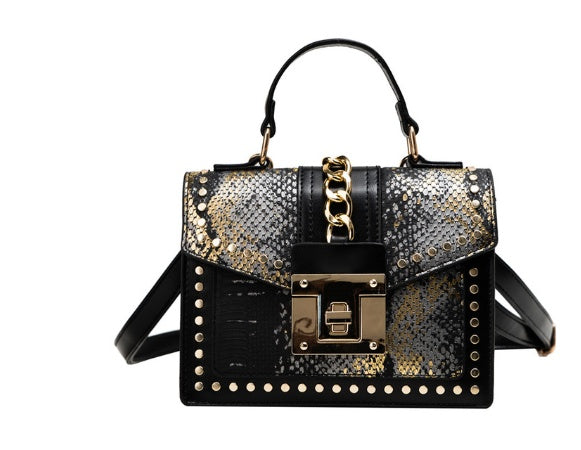 Black women's crossbody alligator bag with gold chain and studded details