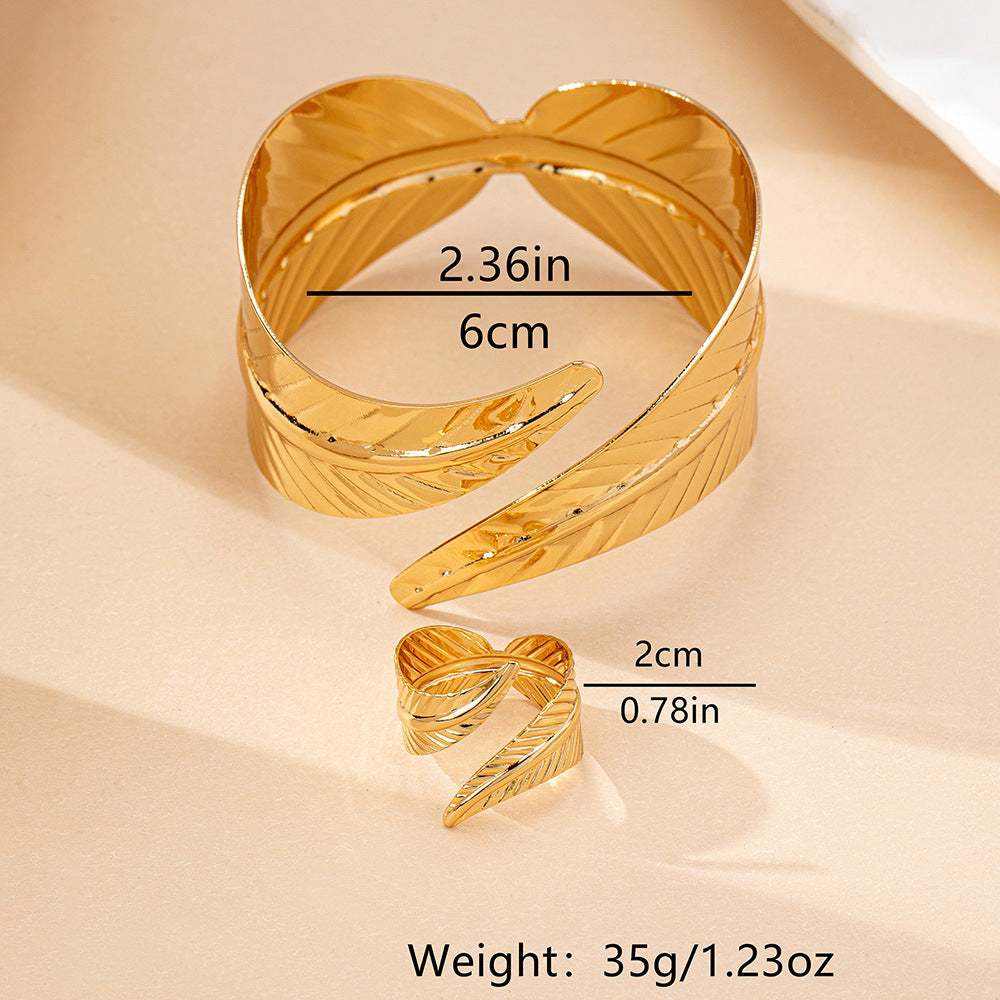 Gold open cuff bracelet with measurements on a beige background