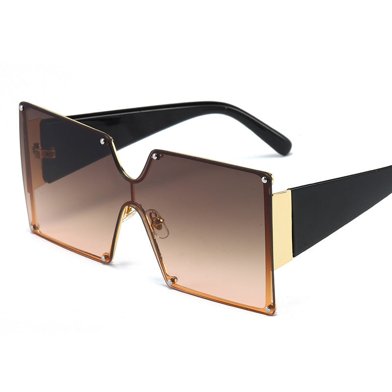 Sunglasses with a gradient brown lens and black and gold frame on a white background