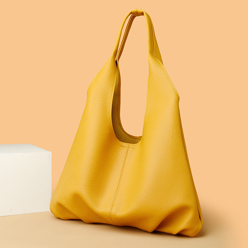 Yellow underarm shoulder bag on a beige background