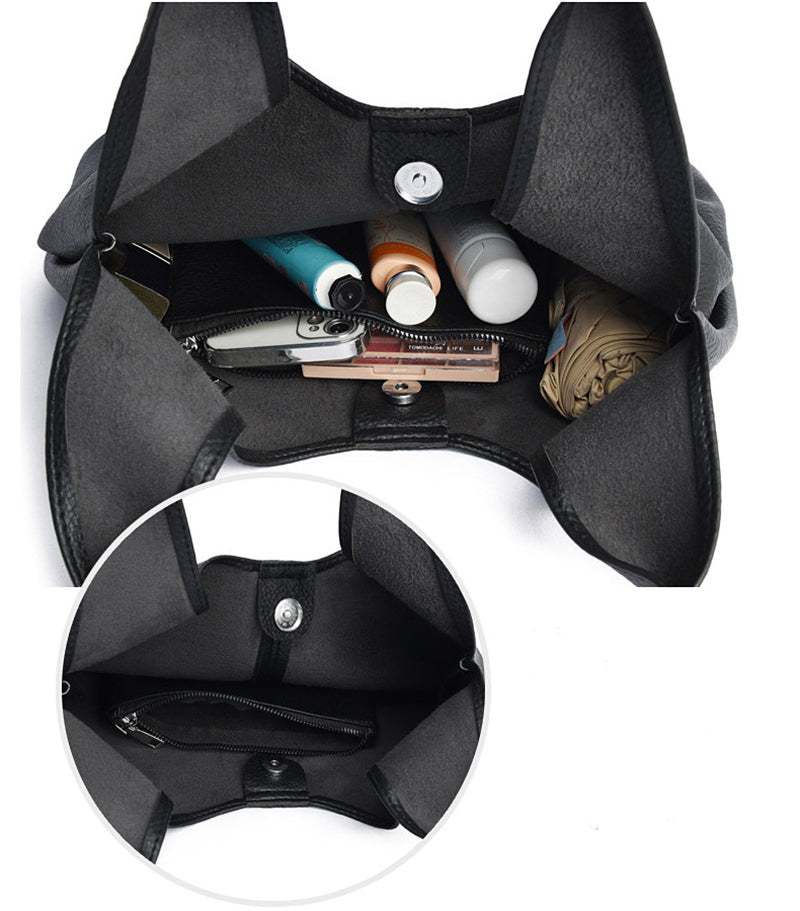 Black leather underarm shoulder bag with various items inside