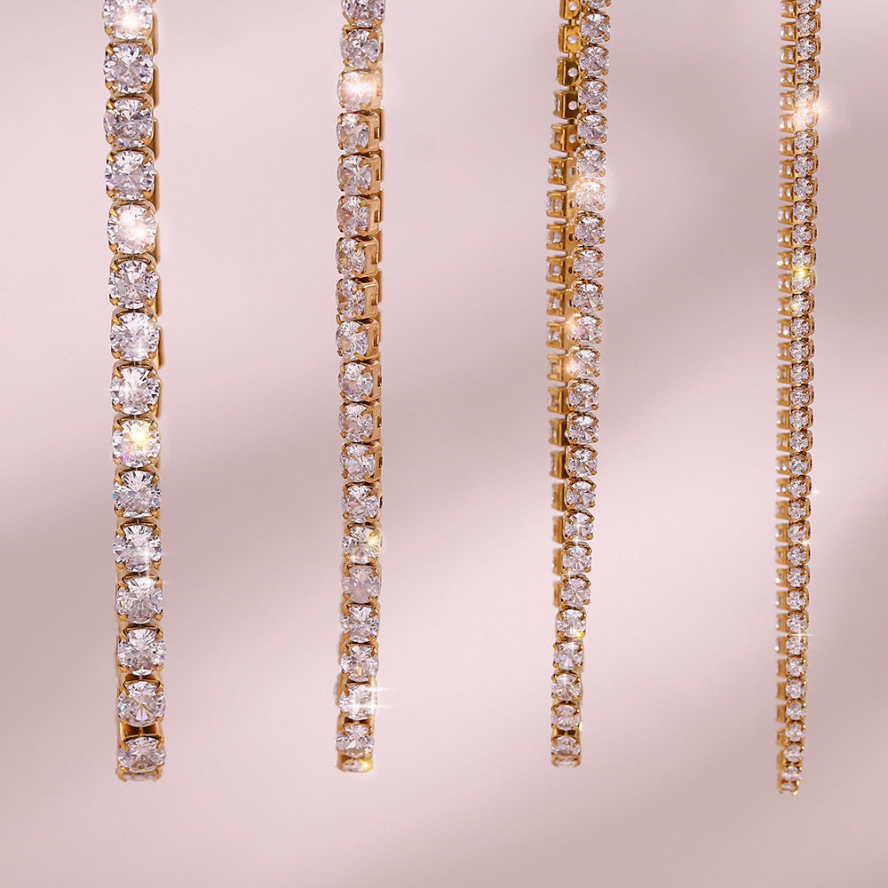 Pair of gold and diamond tennis necklaces on a pink background