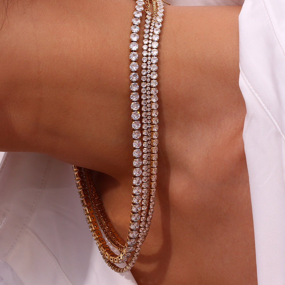 Close-up of a person's neck wearing multiple tennis necklaces on a white background