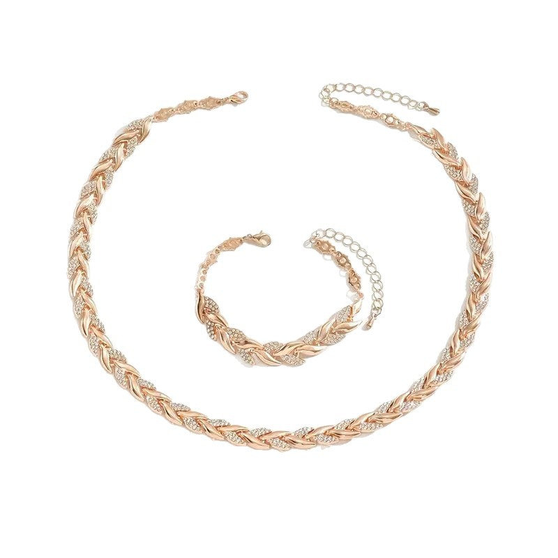 Rose gold braided leaf necklace and bracelet set on a white background
