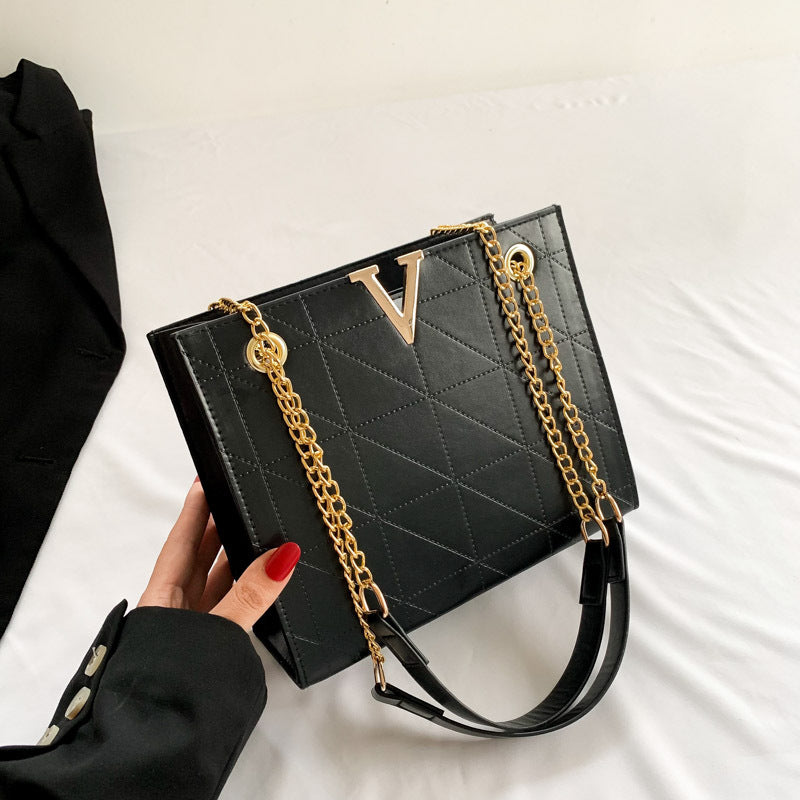 Black women's leather crossbody bag with gold chain strap