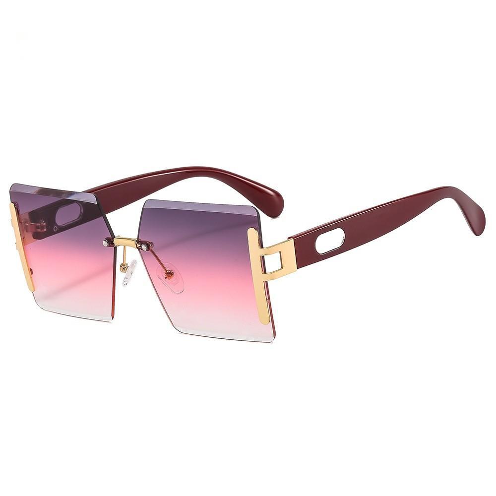 Sunglasses with gradient pink and purple lenses and gold accents on a white background