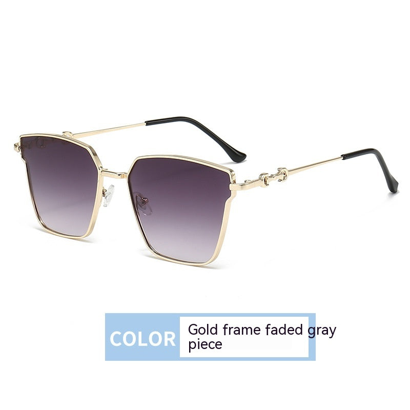 Sunglasses with gold frame and gray gradient lenses on a white background