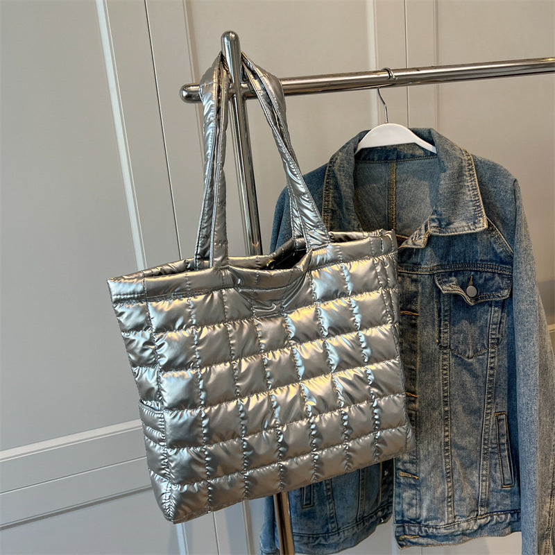 Silver quilted women's plaid shoulder bag and denim jacket hanging on a rack