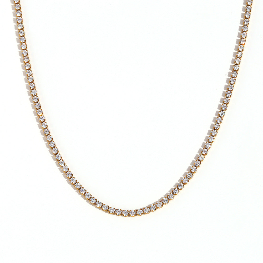 Gold tennis necklace with clear stones on a white background