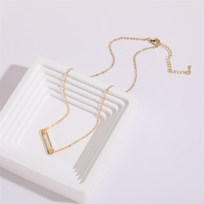 Gold pendant necklace on a white surface
