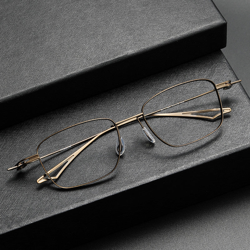 Gold-framed eyeglasses on a dark surface