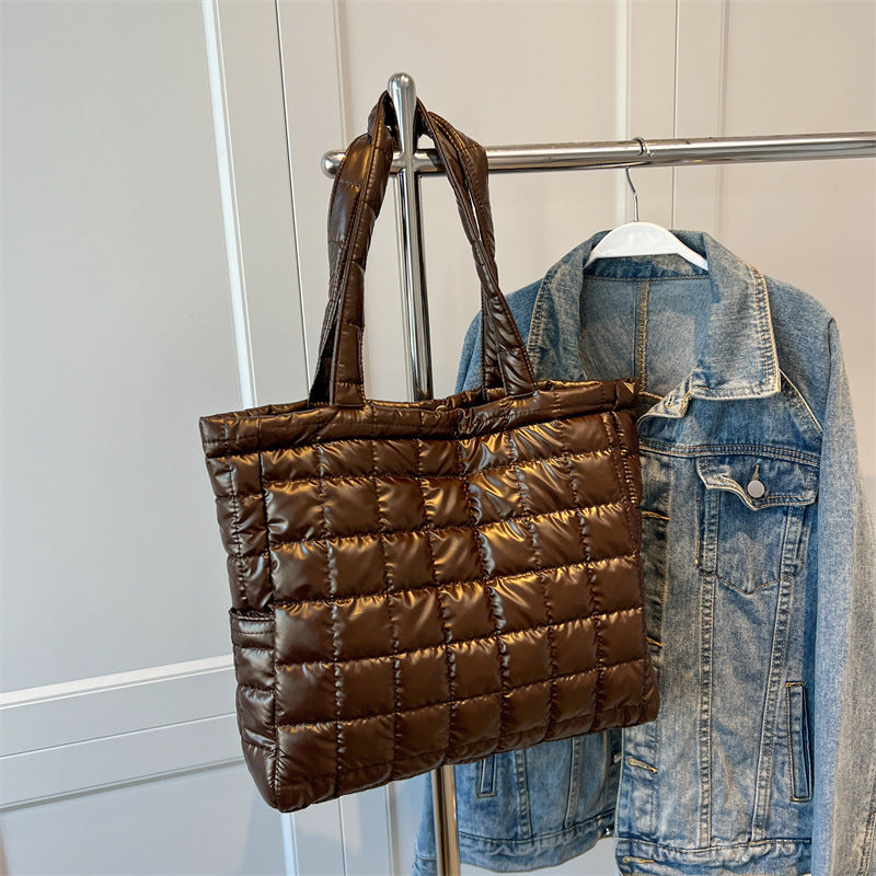 Brown quilted women's plaid shoulder bag and denim jacket on a rack
