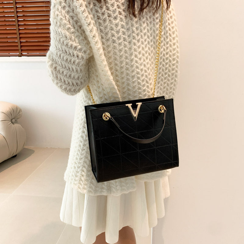Person holding a black women's leather crossbody bag
