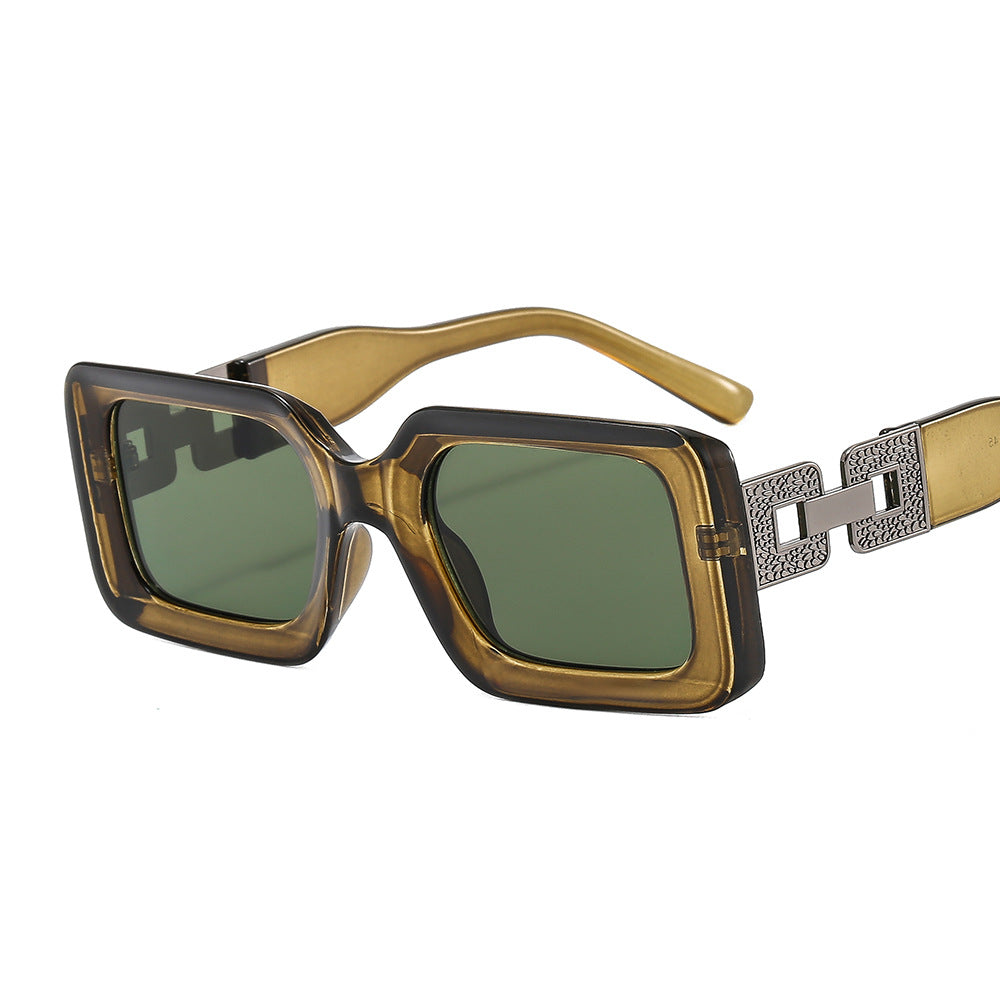 Sunglasses with gold frame and green lenses on a white background