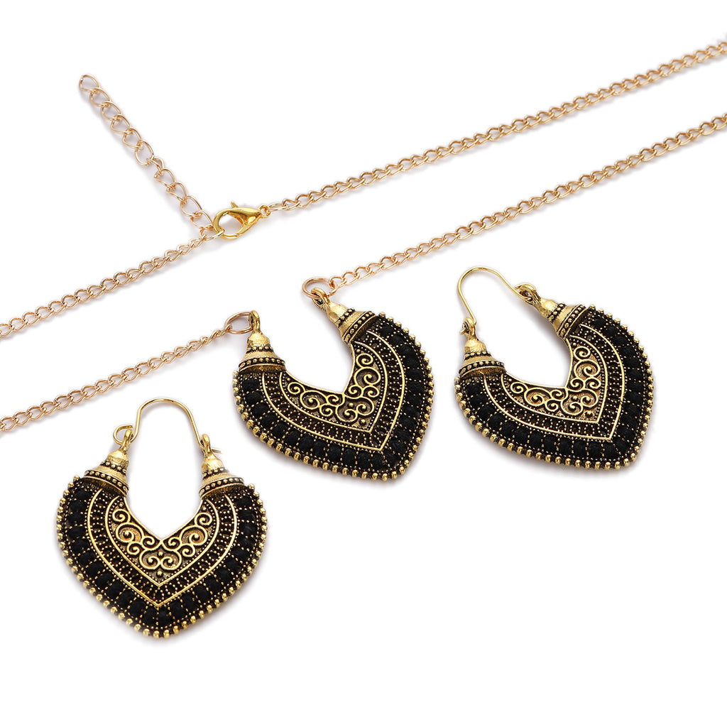 Gold and black heart-shaped earrings with a necklace on a white background