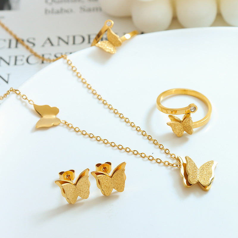 Gold butterfly jewelry set including necklace, butterfly earrings, and ring