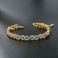 Gold heart bracelet with diamond accents on a dark surface