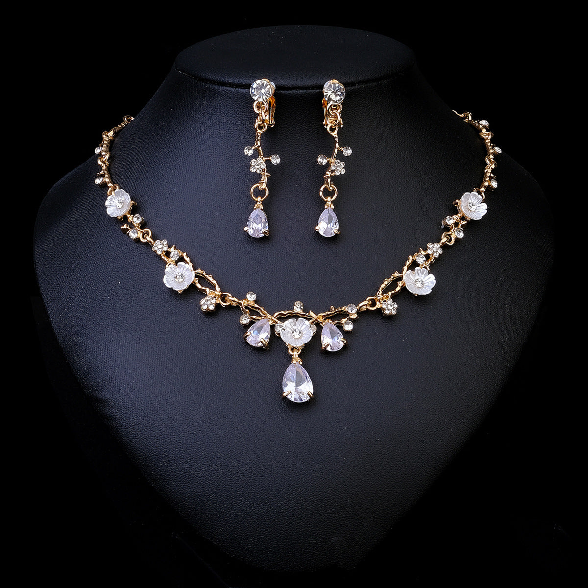 necklace set with earrings on a black stand