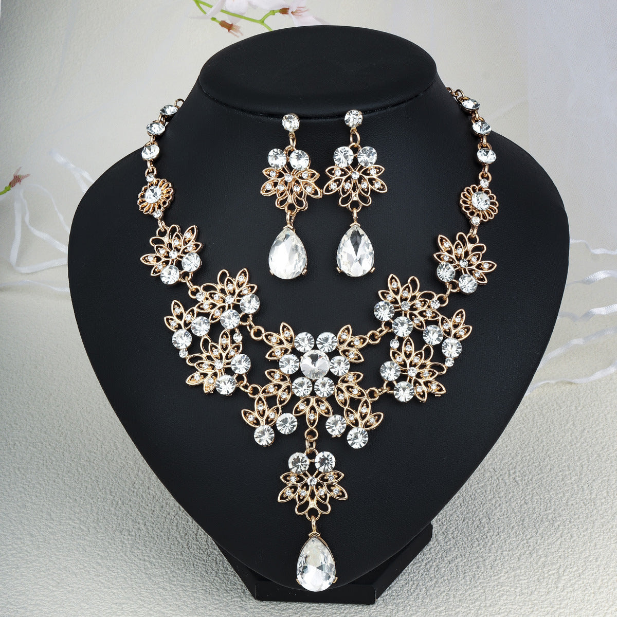 pearl necklace set with earrings on a black stand