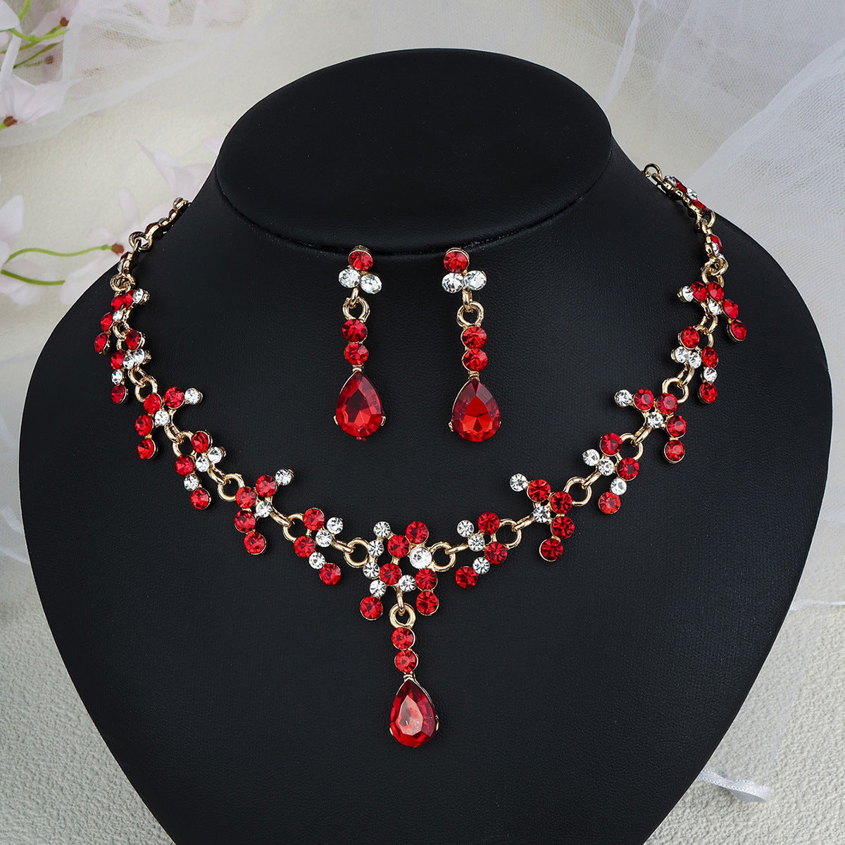 Red and gold pearl necklace set on a black mannequin bust