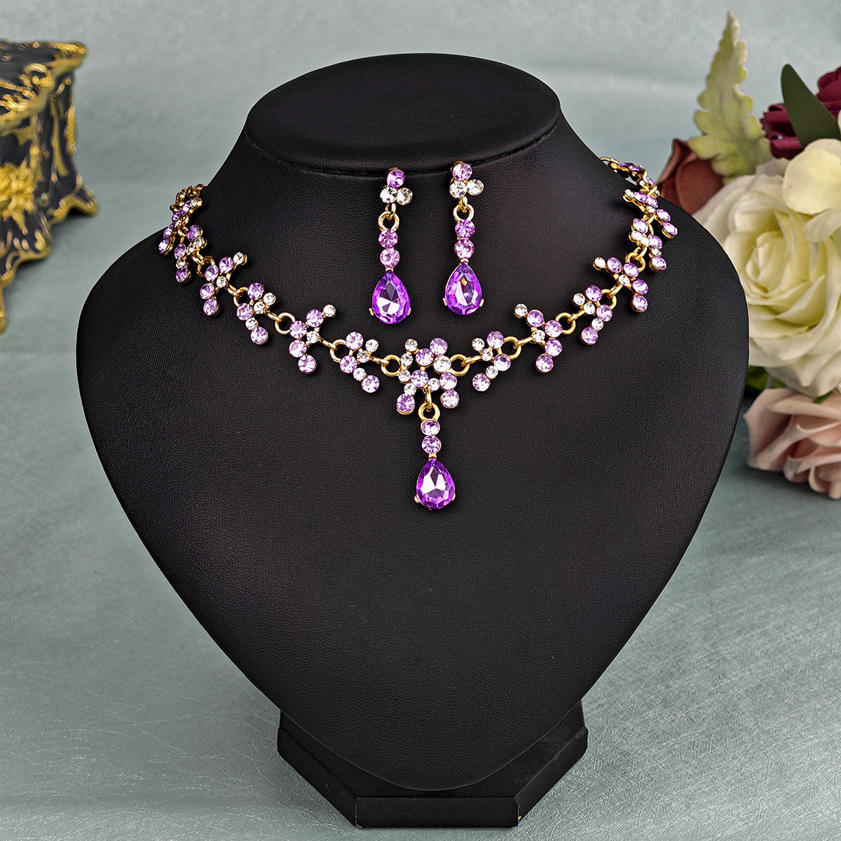 sapphire pearl necklace set with earrings on a black stand