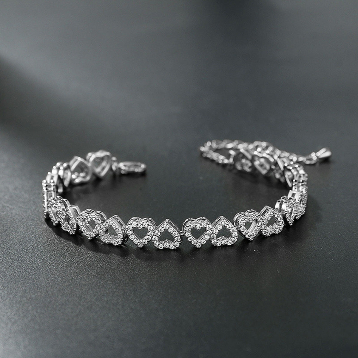 Silver diamond heart bracelet on a dark surface