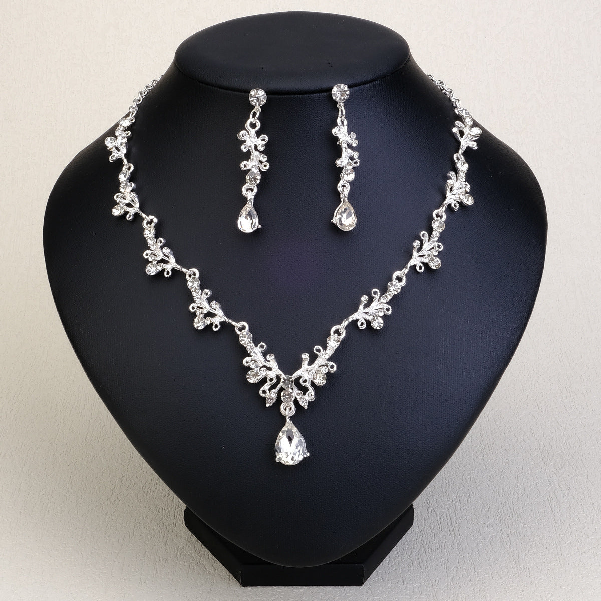 Silver pearl necklace and earrings set on a black mannequin bust