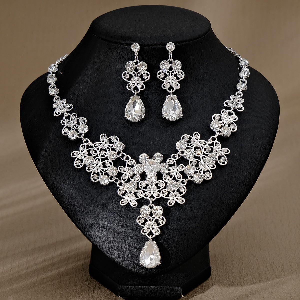 Silver pearl necklace and earrings set on a black mannequin bust
