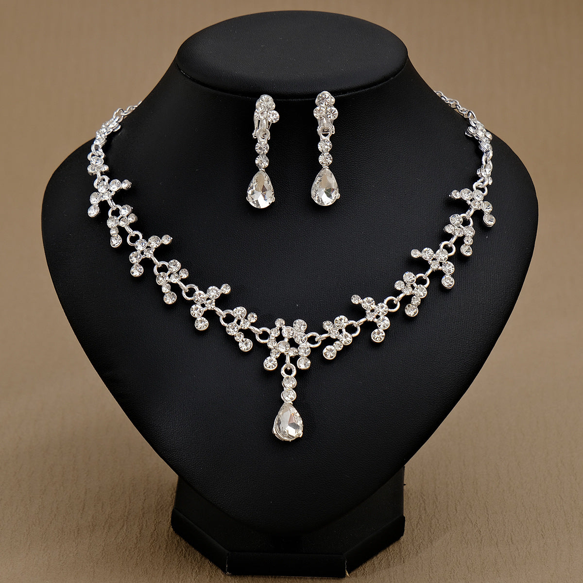 Silver pearl necklace and earrings set on a black mannequin display