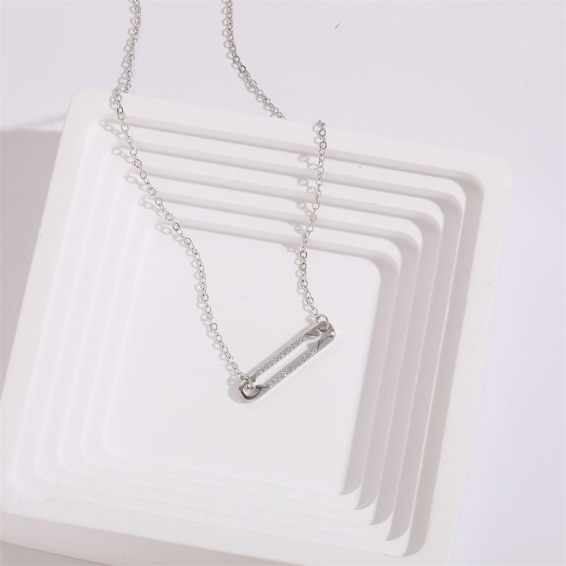 view of a pendant necklace with a rectangular pendant on a white surface